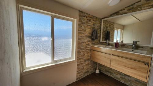 a bathroom with a sink and a large window at La Casa de Coke in Hualaihué