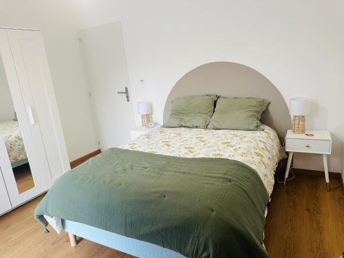 a bedroom with a large bed with a white headboard at Bel appartement proche du lac in Duingt