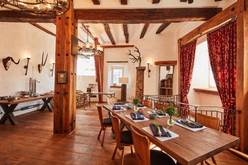 a dining room with a wooden table and chairs at Burg Honrath in Lohmar