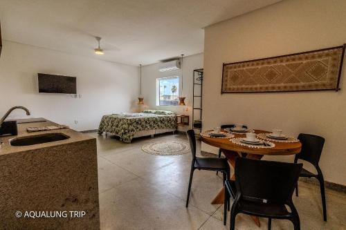 a living room with a table and a bed at Flat Vila Maria in Marechal Deodoro