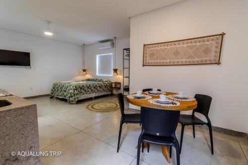a room with a table and chairs and a bed at Flat Vila Maria in Marechal Deodoro