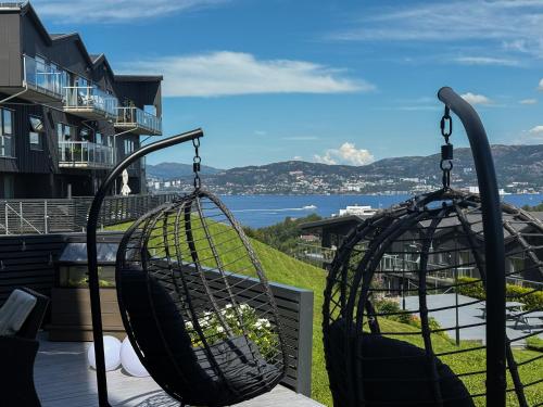 a swing on a porch with a view of the water at Large luxurious apartment with private terrace and parking in Bergen