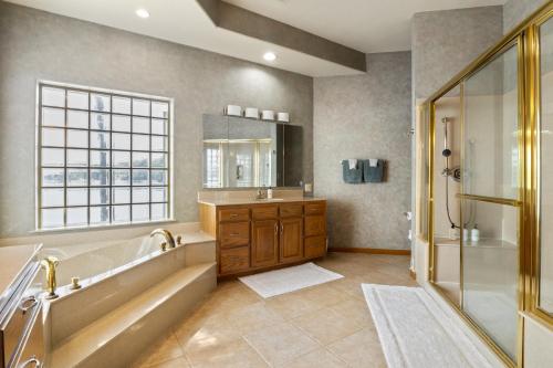 a bathroom with a tub and a shower and a sink at Pet-Friendly Home In The Main Channel w/ Breathtaking Sunsets & Lake Views in Lake Ozark