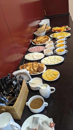 Una mesa larga con platos de comida encima. en Hotel Wintera Gudauri, en Gudauri