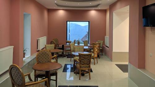a dining room with tables and chairs and a window at Hotel Wintera Gudauri in Gudauri