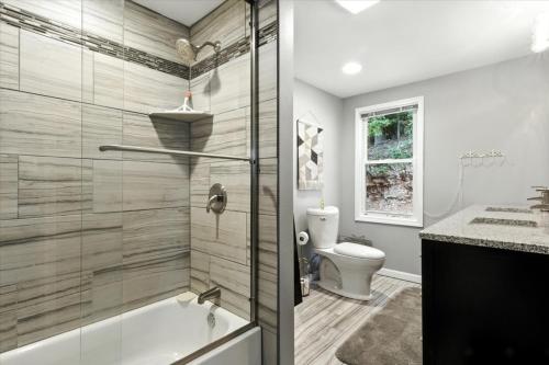 een badkamer met een bad en een toilet bij Lakefront Home w/ Double Deck, Slip, Firepit & Game Room in Sunrise Beach