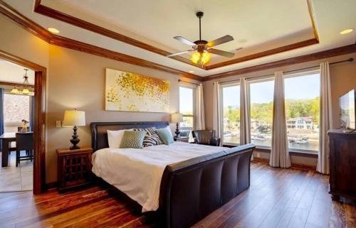 ein Schlafzimmer mit einem Bett und einem Deckenventilator in der Unterkunft Porto Cima w/ Game Room, Dock, Boat Slip, Kayaks, Lakeside Fireplace & Hot Tub in Four Seasons