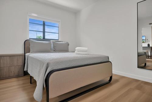 a bed in a white room with a window at Prestige Retreat by Renzzi in Miami