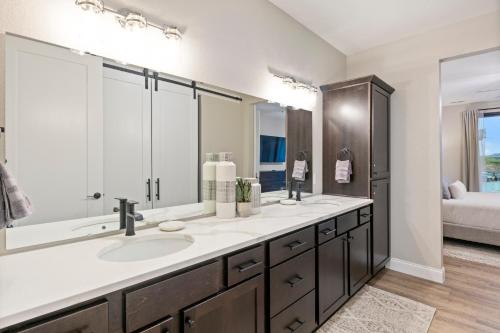 a bathroom with two sinks and a large mirror at Topsider Experience in the Heart of Osage Beach in Laguna Beach