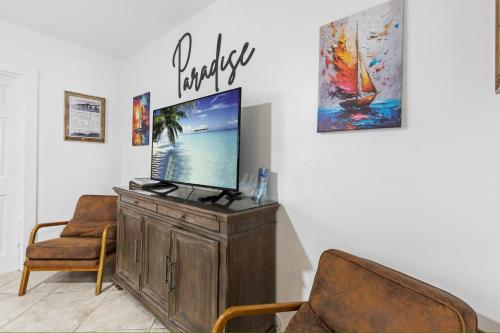 a living room with a tv and two chairs at Prime Downtown Key West Spot - The Cozy Little Cottage in Key West