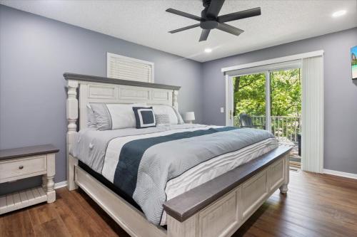 ein Schlafzimmer mit einem großen Bett und einem Deckenventilator in der Unterkunft Stunning Views of the 75mm, Private Dock, Spacious Decks, Kayaks & More! in Buck Creek