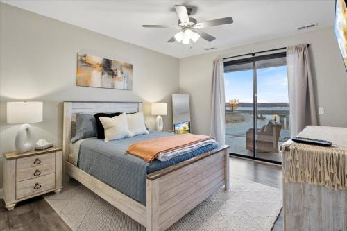 a bedroom with a bed with a ceiling fan at Topsider Condo w/ Updated Design & Amazing Main Channel Views in Laguna Beach