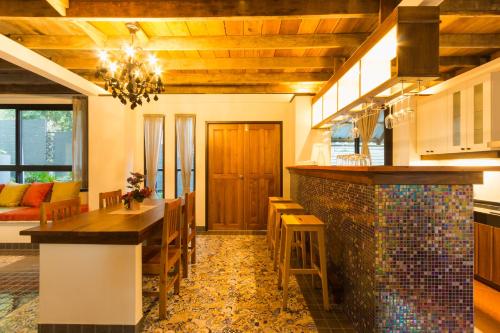 a kitchen with a table and a dining room at Kata Tranquil Villa - SHA Plus in Karon Beach