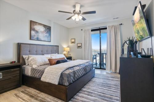 a bedroom with a bed and a ceiling fan at Newly Designed Topsider Condo w/ Beautiful Main Channel Views in Laguna Beach