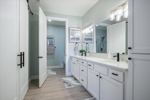 a bathroom with two sinks and a large mirror at Newly Designed Topsider Condo w/ Beautiful Main Channel Views in Laguna Beach