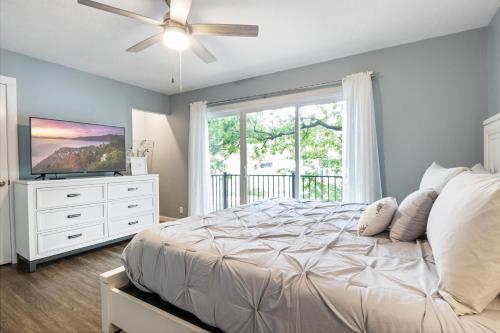 a bedroom with a bed with a ceiling fan and a television at Our Cove Retreat - Perfect for Wave-Free Swimming, Tanning & Prime Location Fun! in Lake Ozark