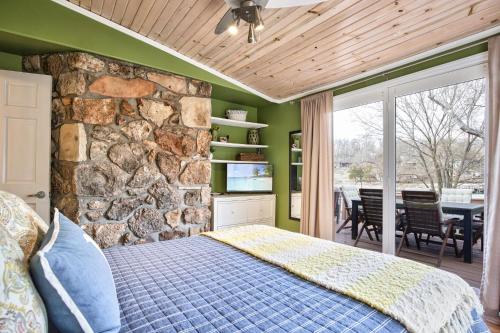een slaapkamer met een stenen muur en een bed bij Lakefront Oasis with Skylights & Covered Boat Slip For Extra Adventure in Laguna Beach