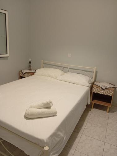 a white bed with two towels on top of it at Ilektras Haus in Mavrommátion