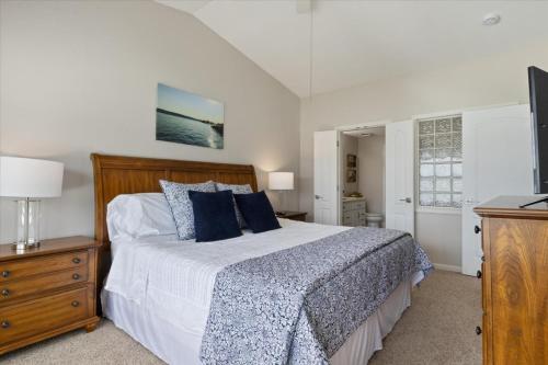a bedroom with a large bed with blue pillows at Main Channel Views, Screened Porch, Pool & Boat Slip in Lake Ozark
