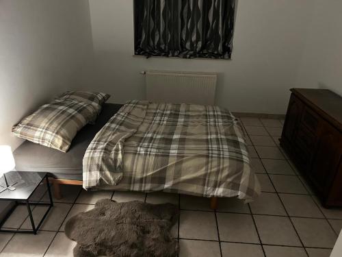 a bedroom with a bed with a plaid blanket on it at Grâce in Grâce-Hollogne