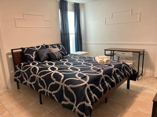 ein Schlafzimmer mit einem Bett mit einer schwarz-weißen Bettdecke in der Unterkunft Master Bedroom w Pvt Bath in shared home in Royal Palm Beach
