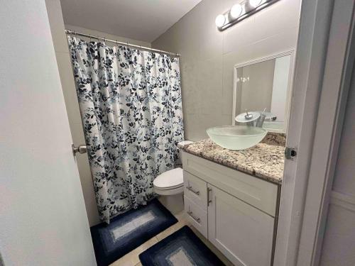 ein Badezimmer mit Waschbecken, Toilette und Dusche in der Unterkunft Master Bedroom w Pvt Bath in shared home in Royal Palm Beach