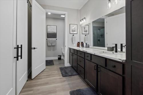 Un baño con dos lavabos y un espejo grande. en Upscale Lakeside Condo with Extraordinary Amenities at Topsider in Osage Beach 19mm, en Laguna Beach