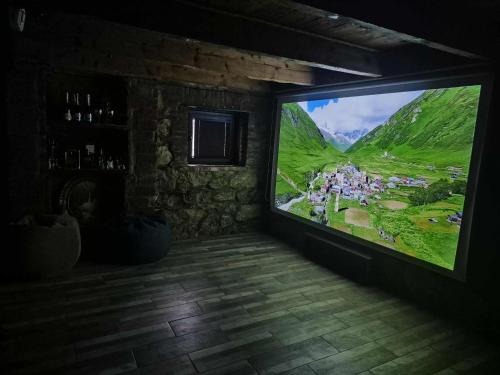a large flat screen tv in a room with a mountain at Cozy Spot in Kutaisi