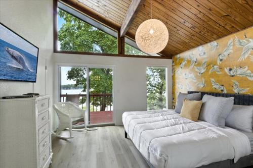 een slaapkamer met twee bedden en een bank en ramen bij Hot Tub, Main Channel Views, Great Outdoor Spaces, Blackstone in Sunrise Beach