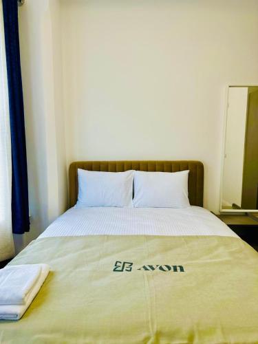 ノッティンガムにあるAvon Stone Apartmentsの「エボン」と書かれた掛け布団が掛けられたベッド