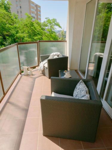 a balcony with two chairs and a couch on it at Spacious Apartment,Balcony&Garage in Bratislava