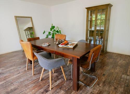 a wooden dining room table with chairs and a mirror at Spacious Apartment,Balcony&Garage in Bratislava