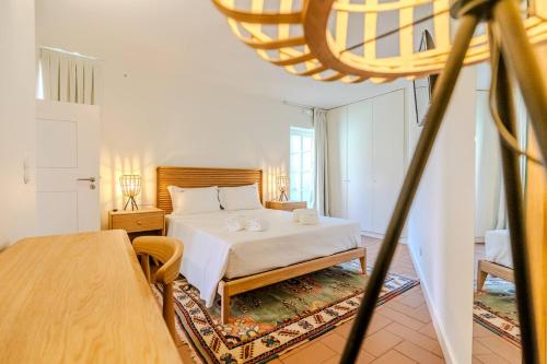 a bedroom with a white bed and a table at Private Villa T8 - Casa Da Bra Viana Do Castelo in Viana do Castelo
