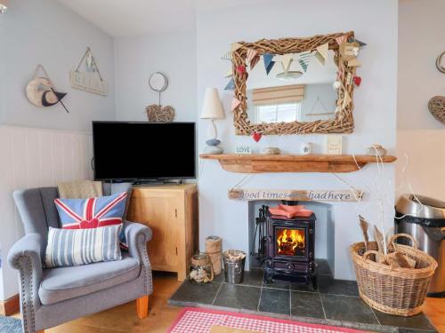 a living room with a fireplace and a tv at Seaside in Lyme Regis
