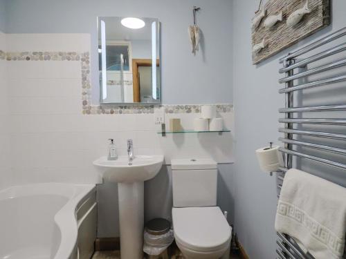 a bathroom with a toilet and a sink and a mirror at Seaside in Lyme Regis