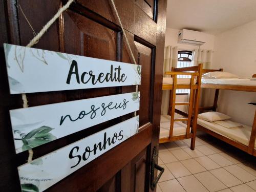 a room with a door with a sign that says associate norwegian sometimes at Odoyá Casa Hostel in Arraial d'Ajuda