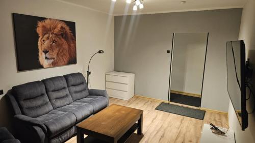 a living room with a couch and a lion on the wall at Lion Stay in Tartu