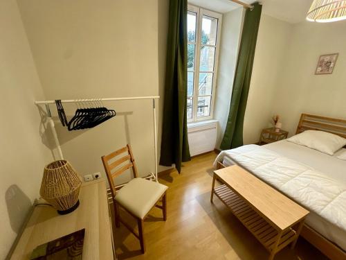 a bedroom with a bed and a chair and a window at Duplex appartement in Bayeux in Bayeux