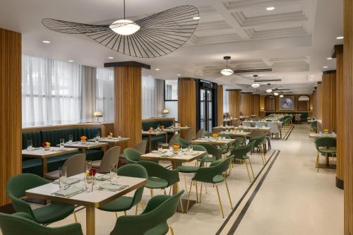 a restaurant with tables and green chairs at Hard Rock Hotel London Ontario in London