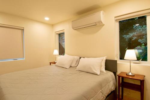 a bedroom with a bed with two lamps and a window at Stunning city views guesthouse in Saint Paul