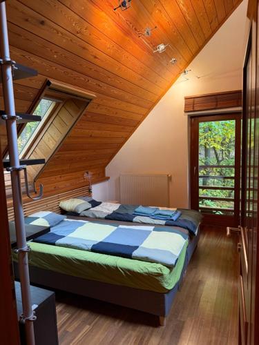 a bedroom with a bed in a wooden ceiling at Calderus house Dobogókő in Pilisszentkereszt