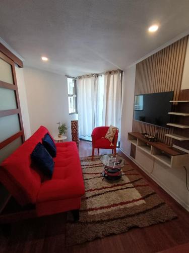 a living room with a red couch and a flat screen tv at Danyedi Apart in Santiago