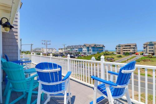 a row of blue chairs on the porch of a house at 5070 - Sandy Bottoms in Croatan Shores