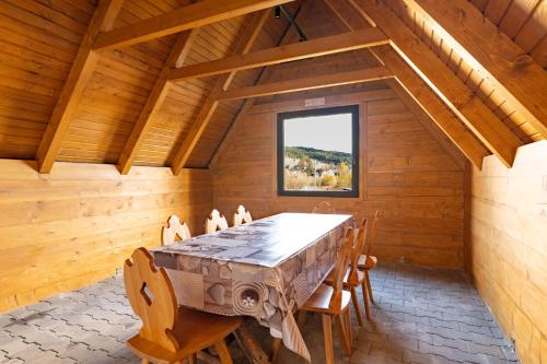 a dining room with a wooden table and chairs at Villach in Bukowina Tatrzańska