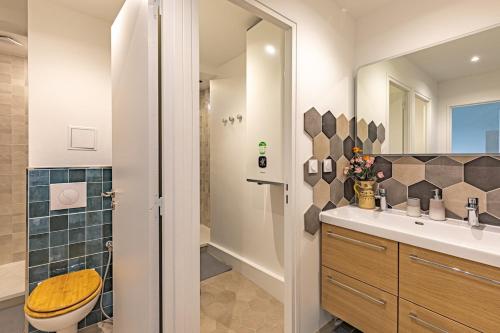 a bathroom with a sink and a toilet and a mirror at Friendly and spacious apartment in Créteil ! in Créteil