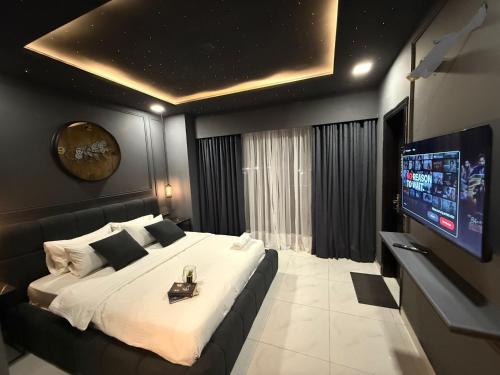 a bedroom with a large bed and a flat screen tv at AirHomes By Zameen Opal in Lahore
