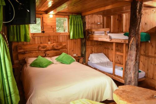 a bedroom with two bunk beds in a log cabin at Casa Mujer Villa Agueda in Chocontá