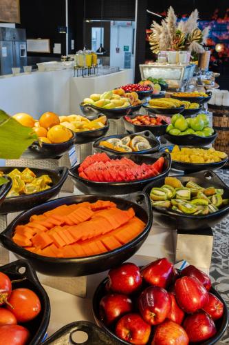 um bufê com muitas tigelas de frutas e vegetais em Hilton Bogota Corferias em Bogotá
