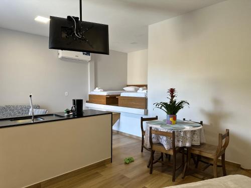 uma cozinha e sala de jantar com uma mesa e uma cama em Loft MarSol em Piúma