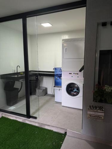 a laundry room with a washing machine and a sink at Studio47 - Compact, equipped and well located in Itajaí